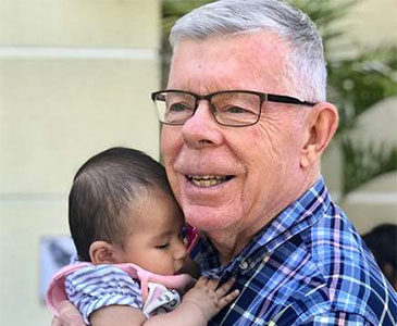 Elderly man holding baby