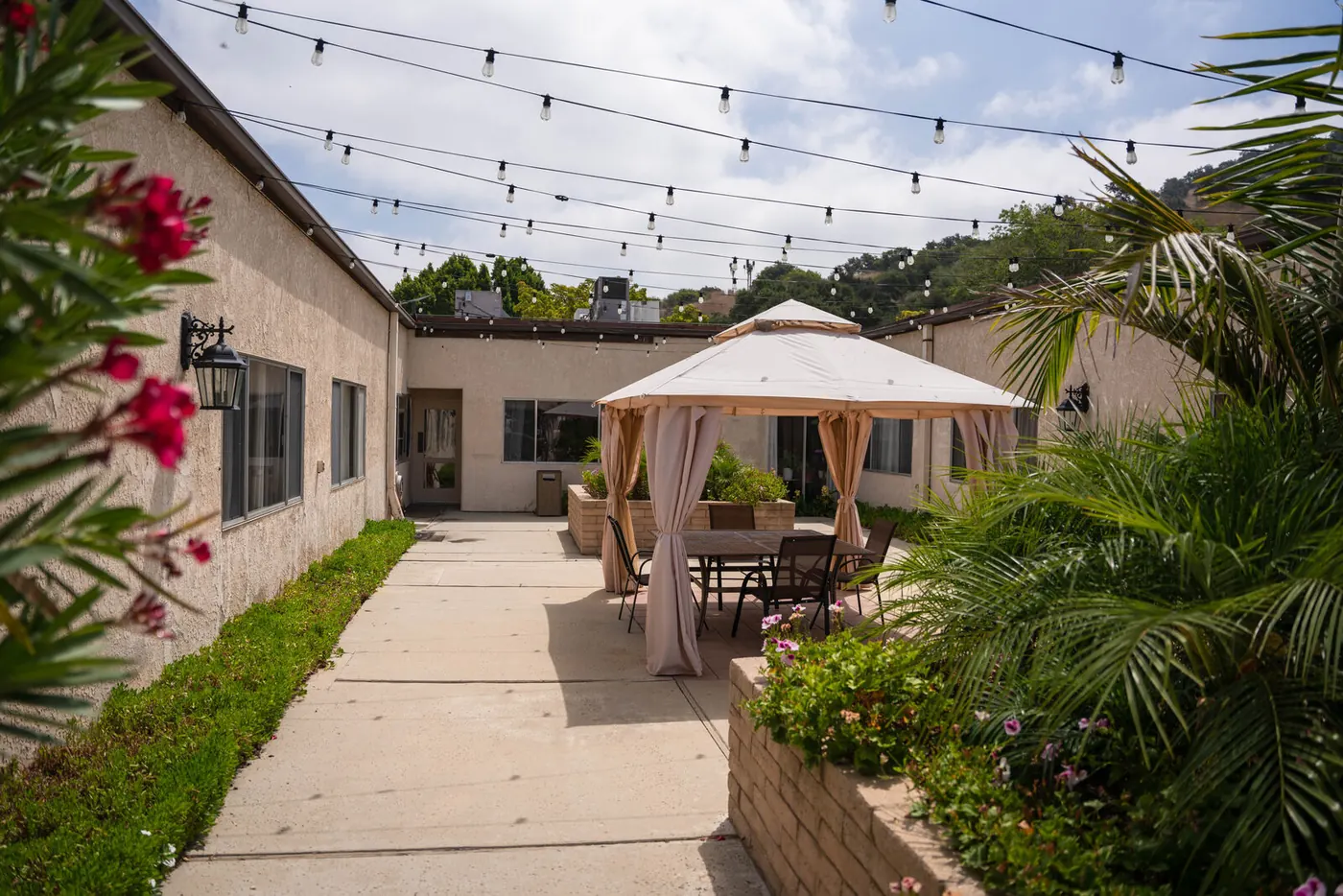 A covered walkway strung with lights, leading to the gazebo