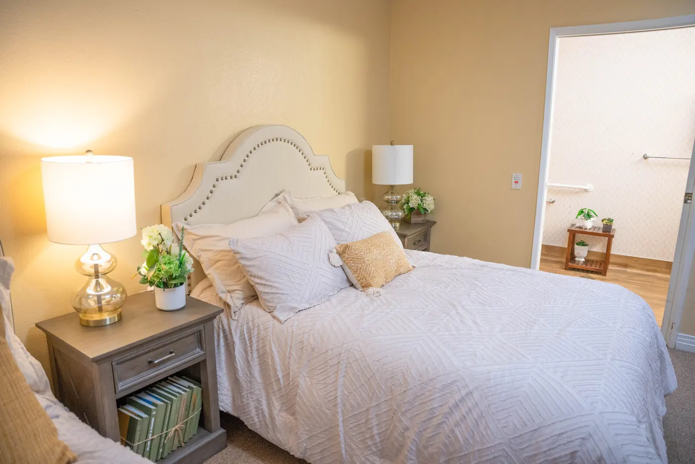 A resident bedroom with bedside lamps and framed art