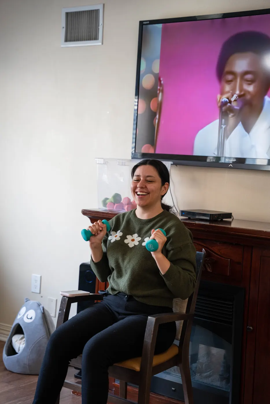 An associate laughing as she leads the hand-weight workout