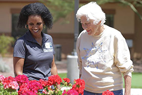 Silverado employee assisting resident in garden