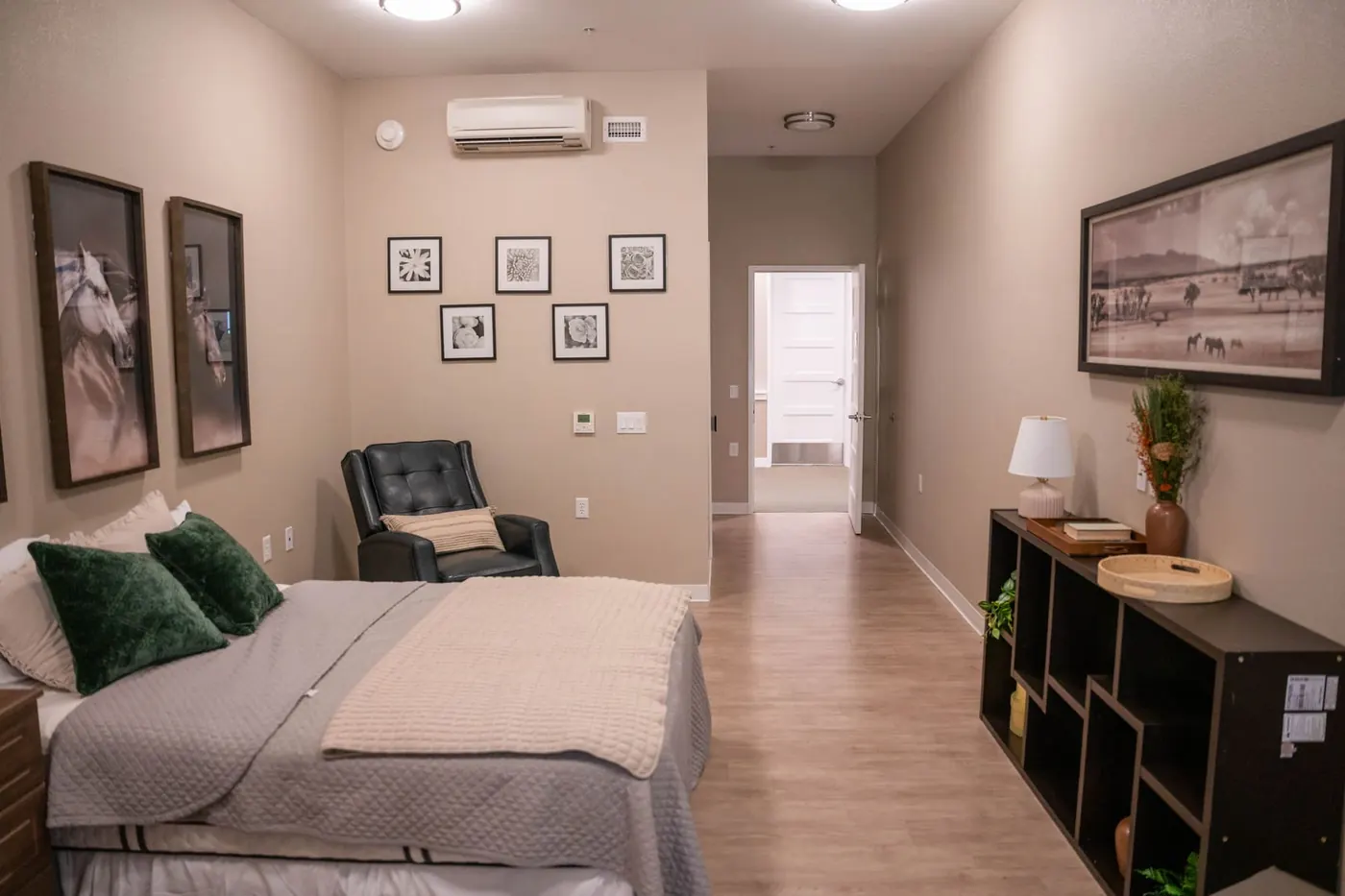 A resident bedroom with a sitting area and shelving