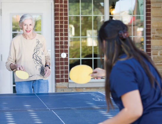 resident playing pingpong with staff member