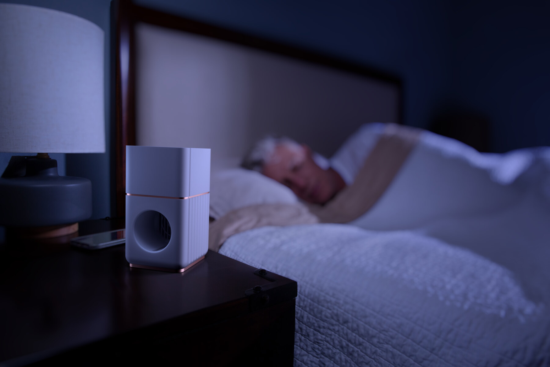 A Memory Air device sits beside a sleeping resident at night
