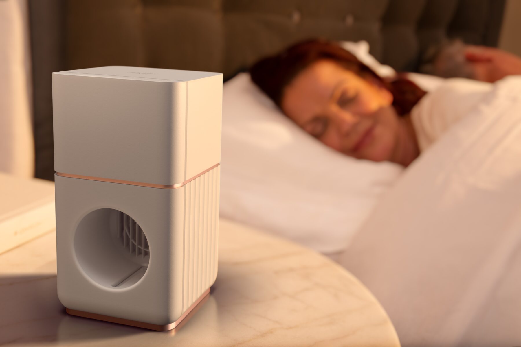A Memory Air device on a bedside table as a woman sleeps